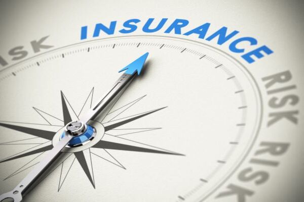 Concept image of a compass pointing to the word "insurance" written in blue
