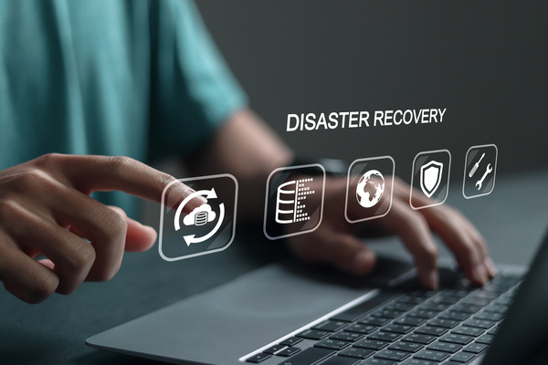 Disaster recovery concept with digital icons above a laptop, highlighting cybersecurity, data backup, and IT support for SMEs in Ipswich