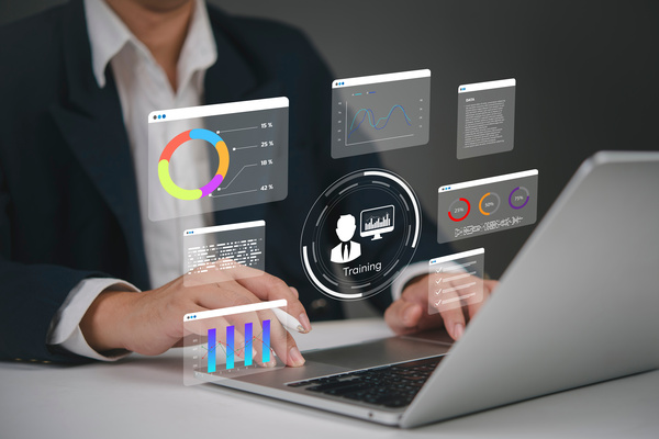 Business professional using laptop with digital training and analytics icons – HR and IT collaboration for cybersecurity in Suffolk and Essex